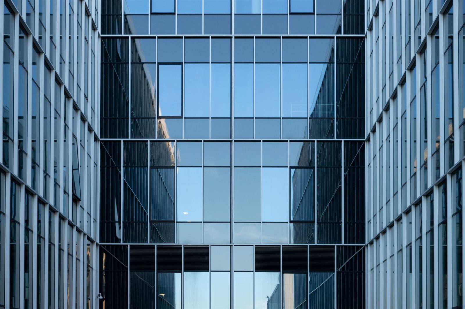 Contemporary building facade with reflective glass windows in an urban environment.
